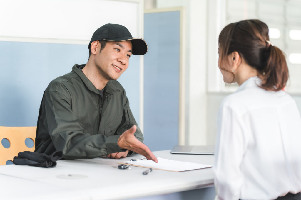 自動車整備工場の受付で説明・見積もり・提案をする整備士