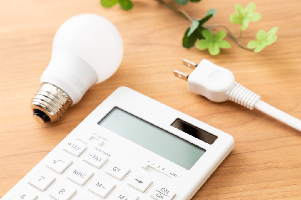 机に置かれた電卓とコンセントプラグ