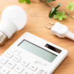 机に置かれた電卓とコンセントプラグ