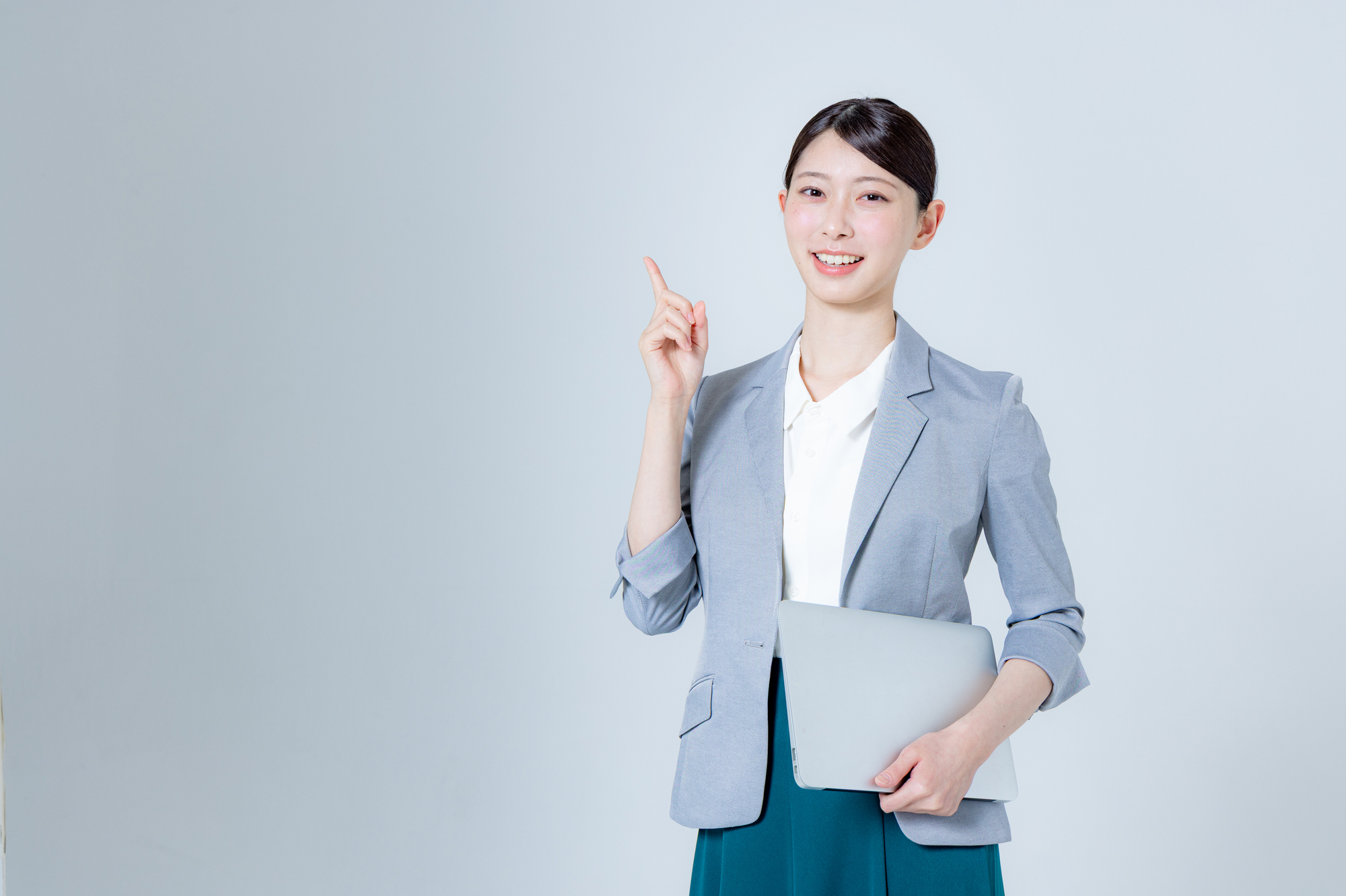 ノートパソコンを持って案内する女性ビジネスパーソン