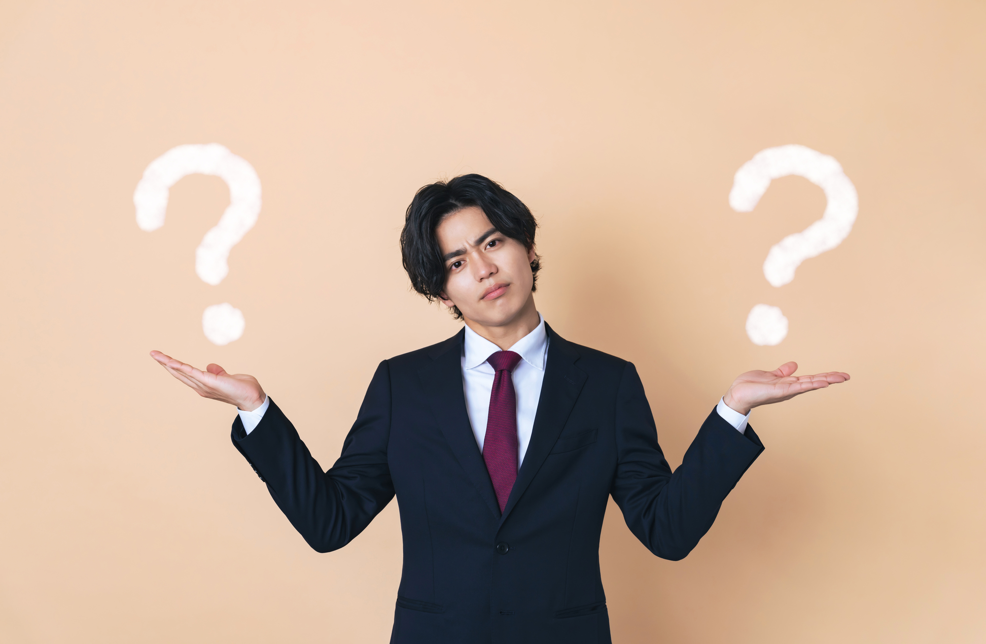 二つのものを比べるスーツを着た若い男