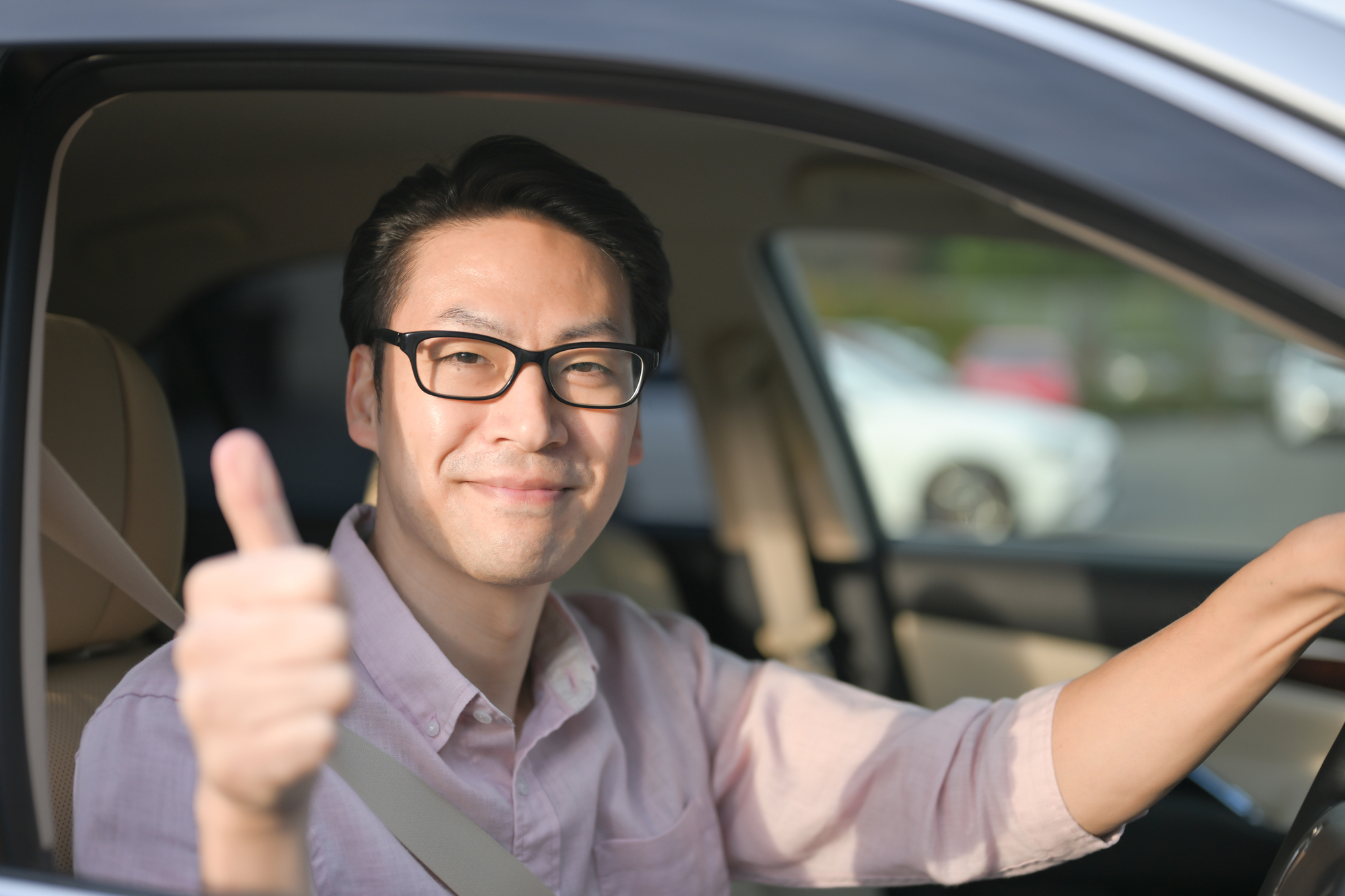 車に乗って笑顔を見せる男性の様子