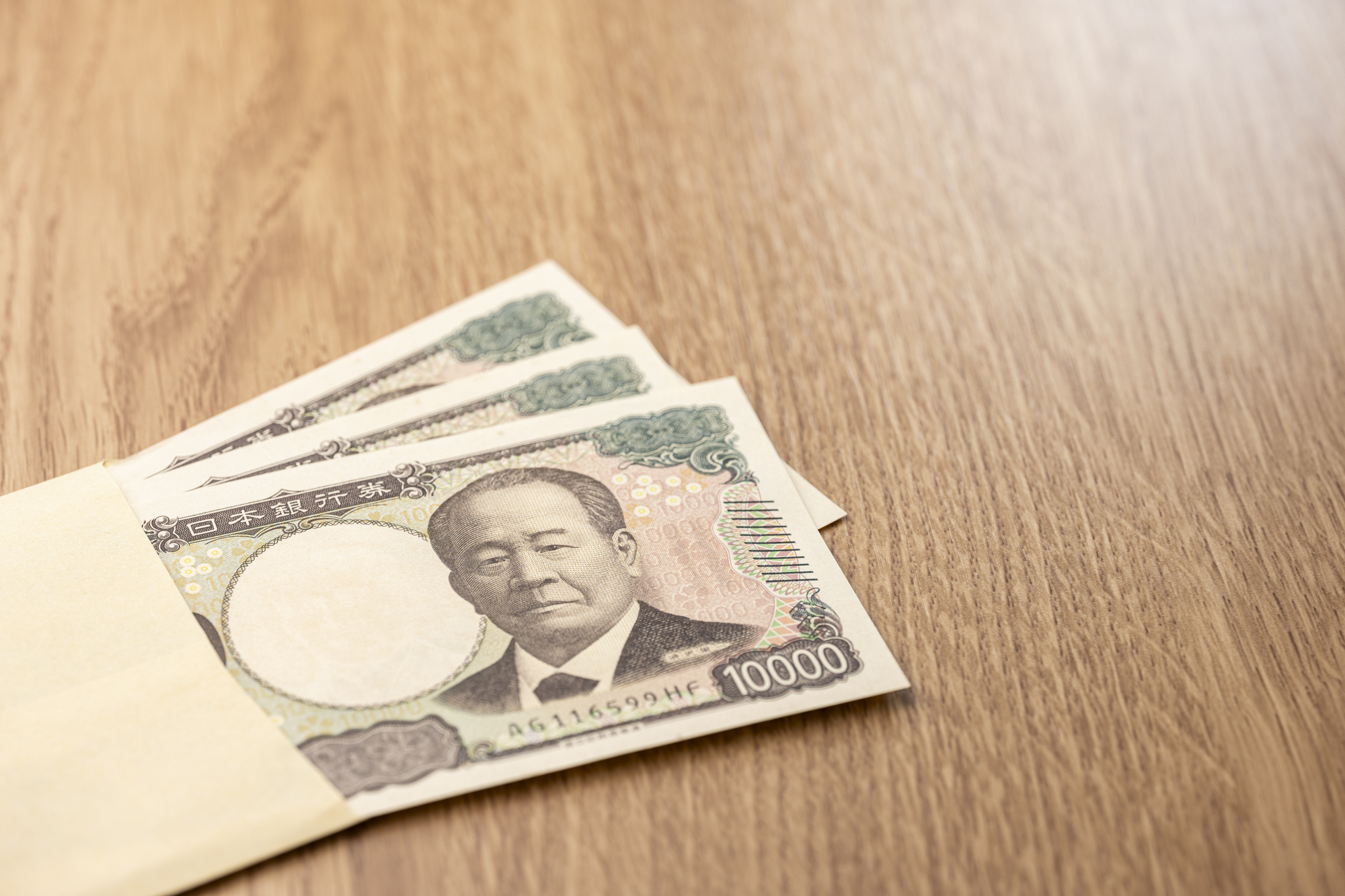 封筒から広がる日本円一万円札と資金のコンセプト