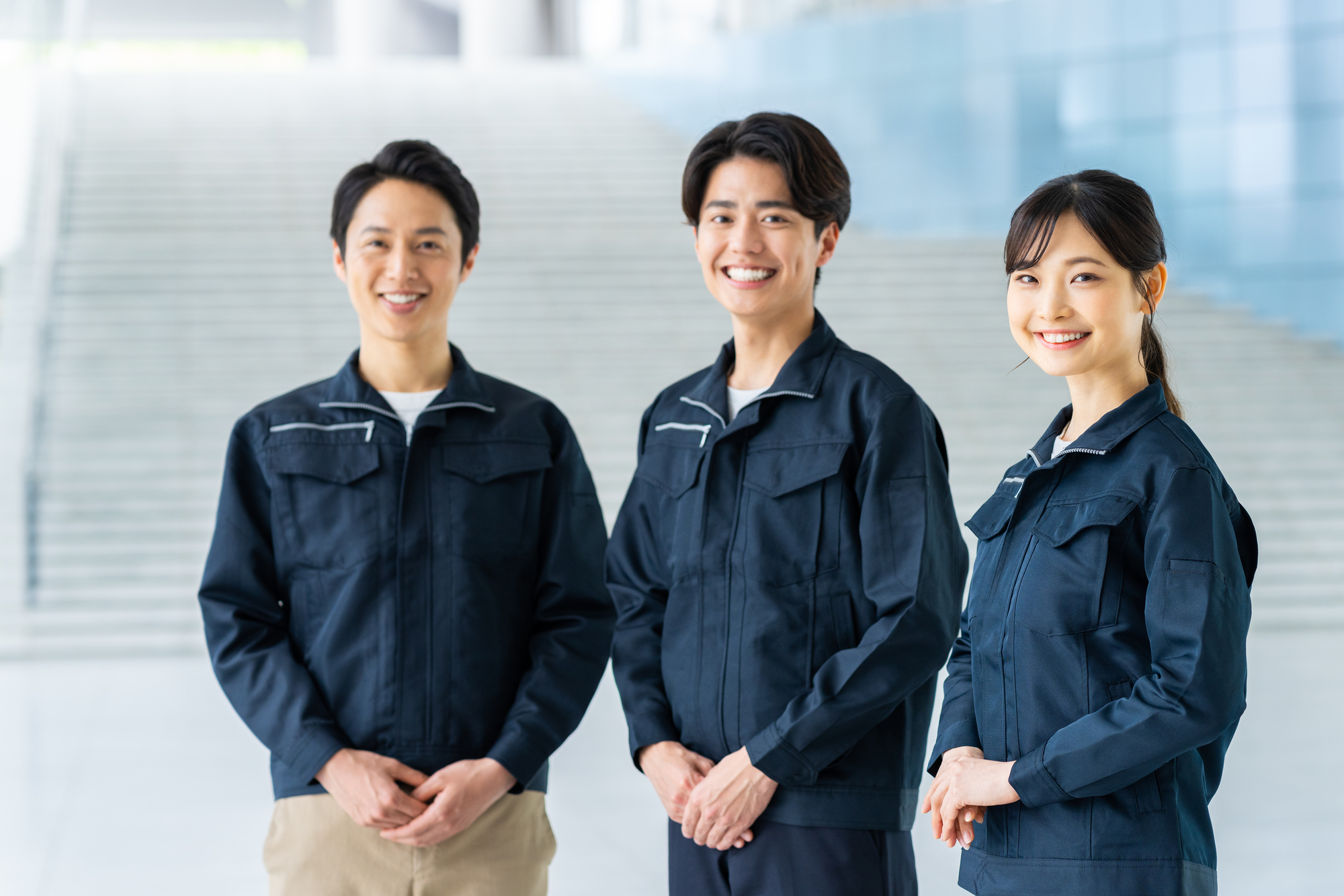 作業着を着て笑顔の3人