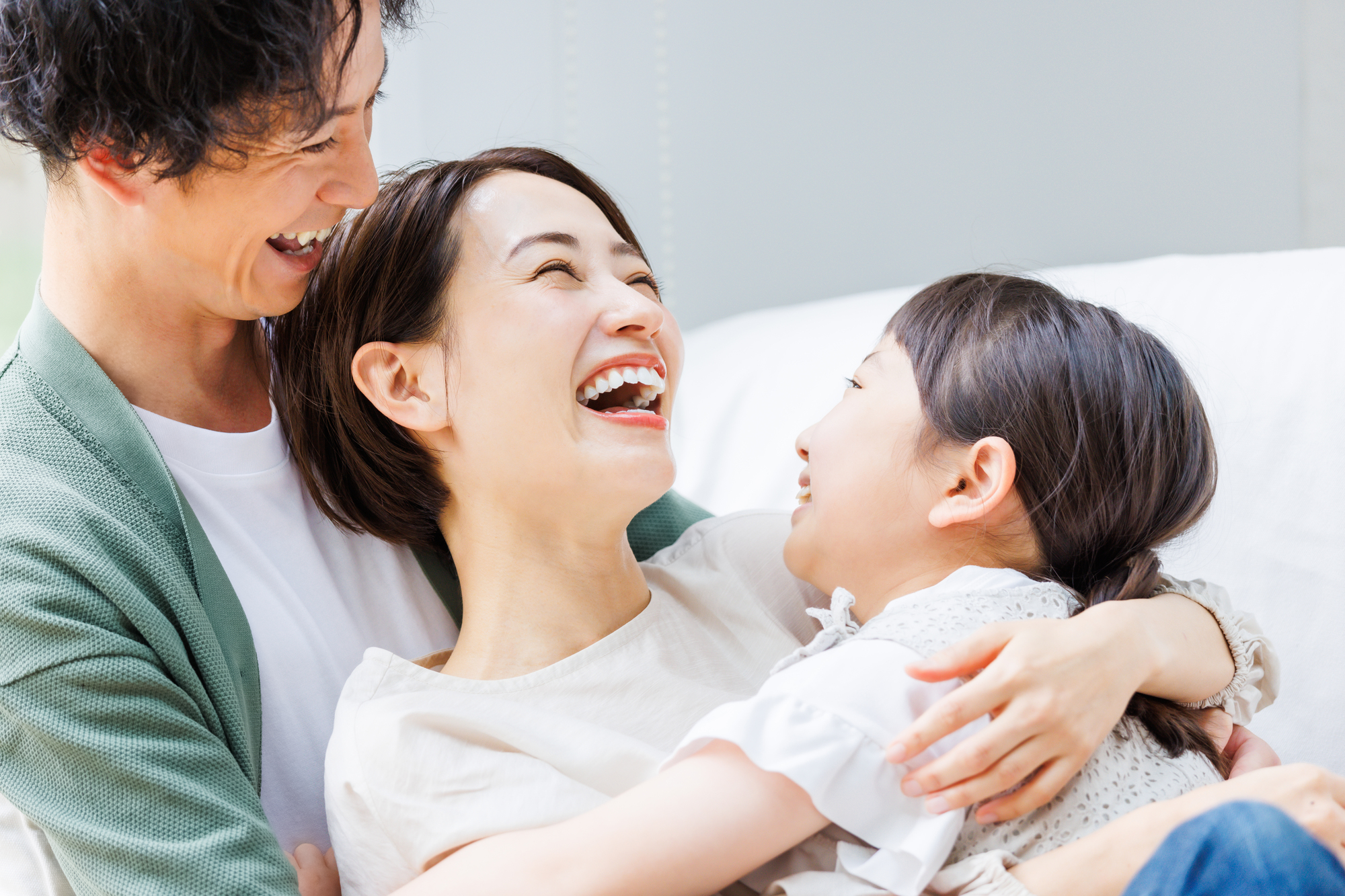 ソファでくつろぐ若い家族