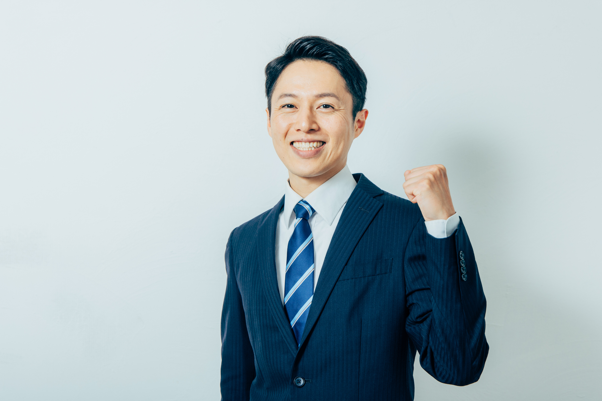 ガッツポーズをしたスーツ姿の男性