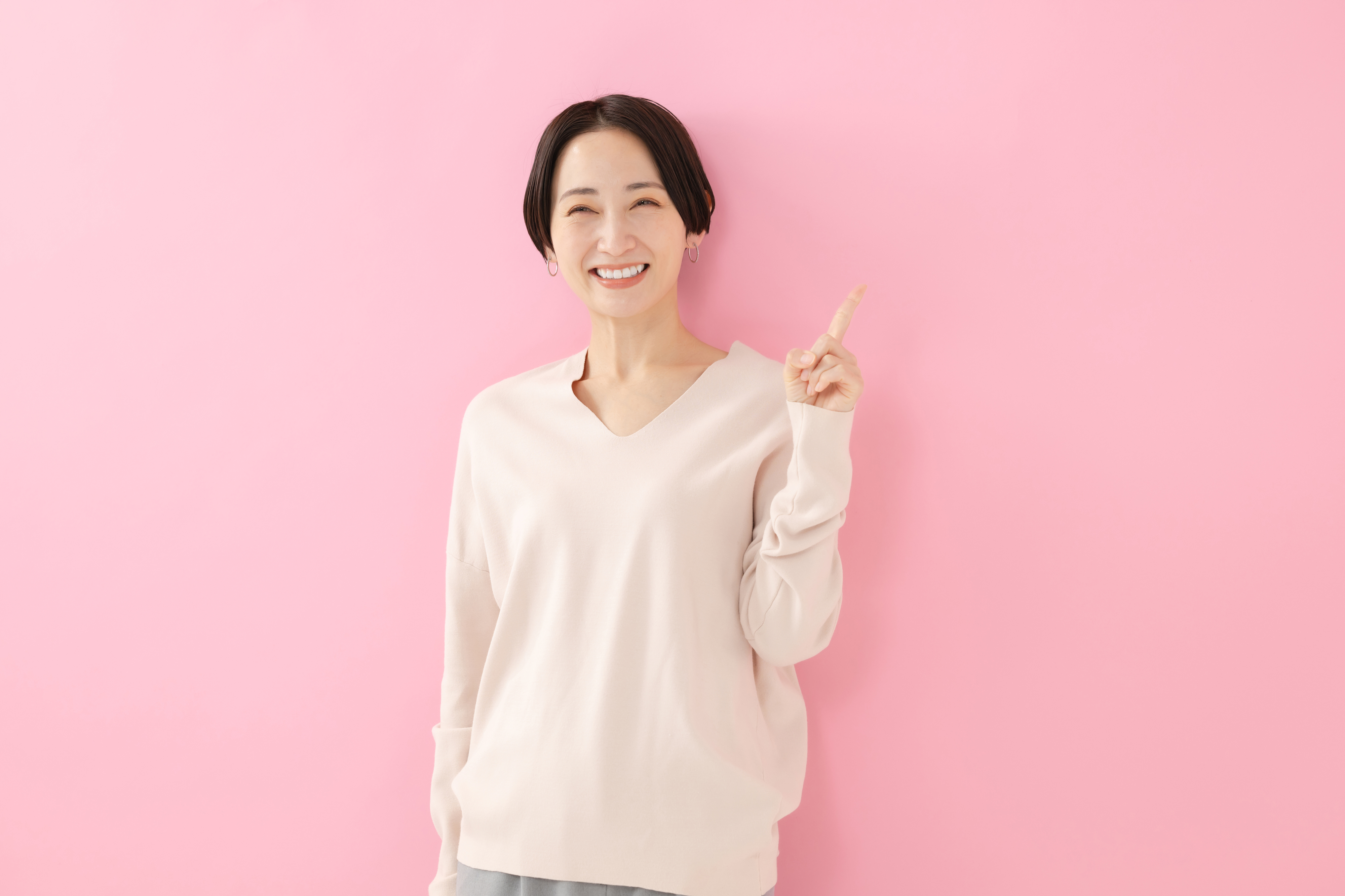 指差しをする笑顔の女性