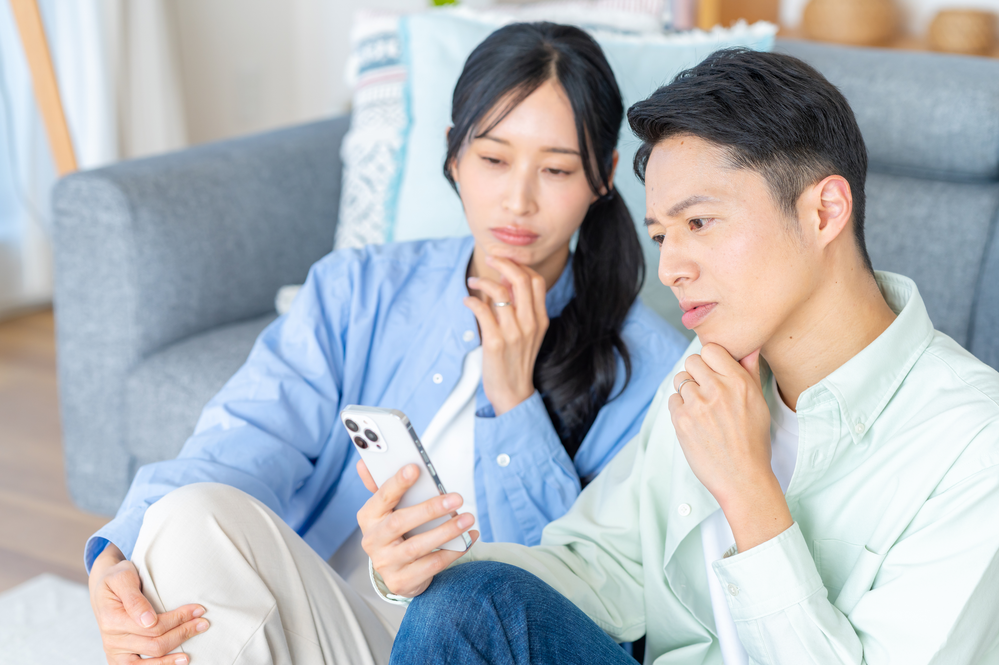 リビングでスマホを見るカップル