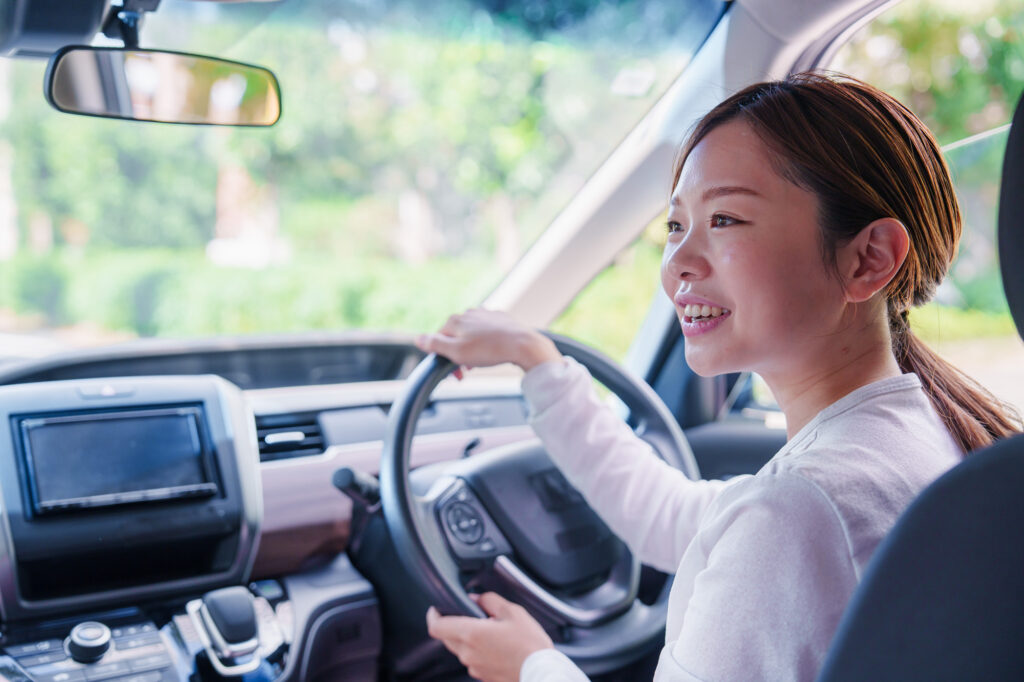 笑顔で車を運転する女性