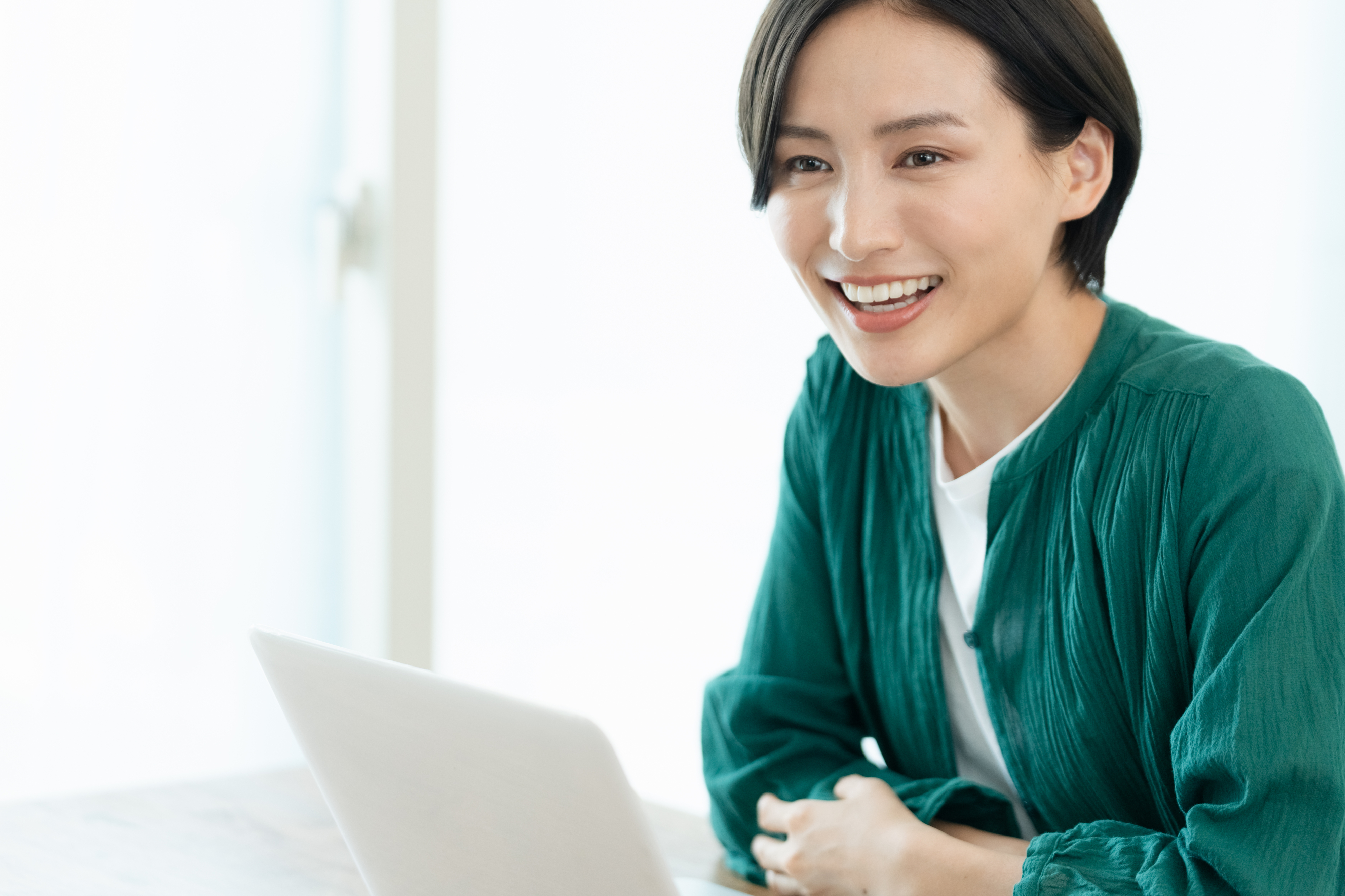 パソコン作業をしながら会話する女性